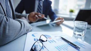 Faire un sondage en ligne avant de se lancer en affaires : est-ce une bonne idée ? Deux hommes analysant des documents