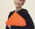 smiling woman standing while holding orange folder